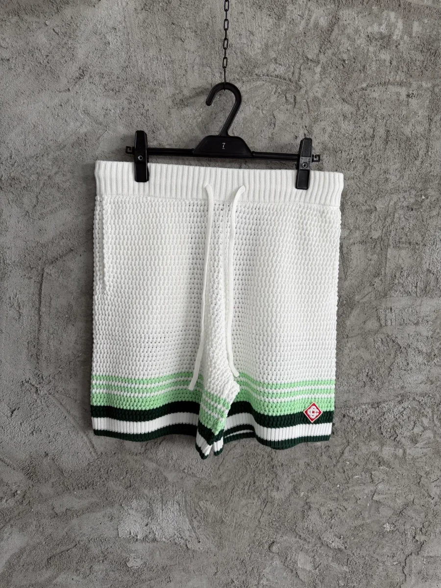 Вязаные белые шорты с зелёными полосками на вешалке, вид спереди