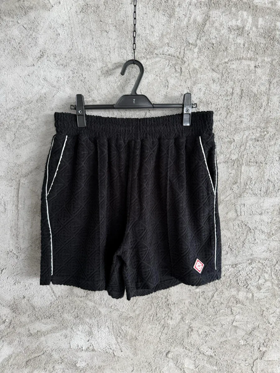 Чёрные жаккардовые шорты на вешалке, вид спереди, белый кант по бокам