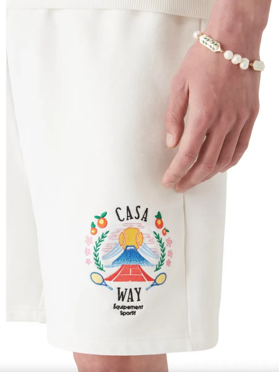 Белые шорты на модели крупным планом с акцентом на вышивку Casa Way