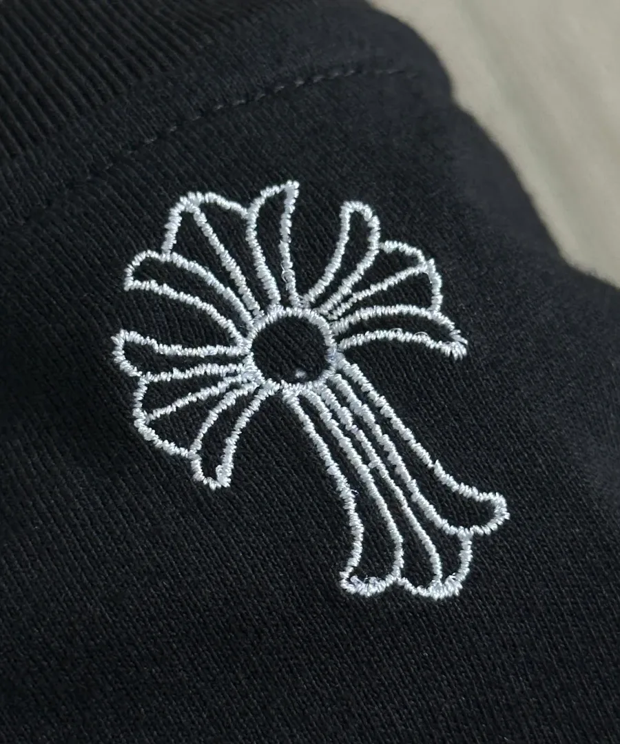 Крупный план вышивки в виде креста на футболке Chrome Hearts GRP Y