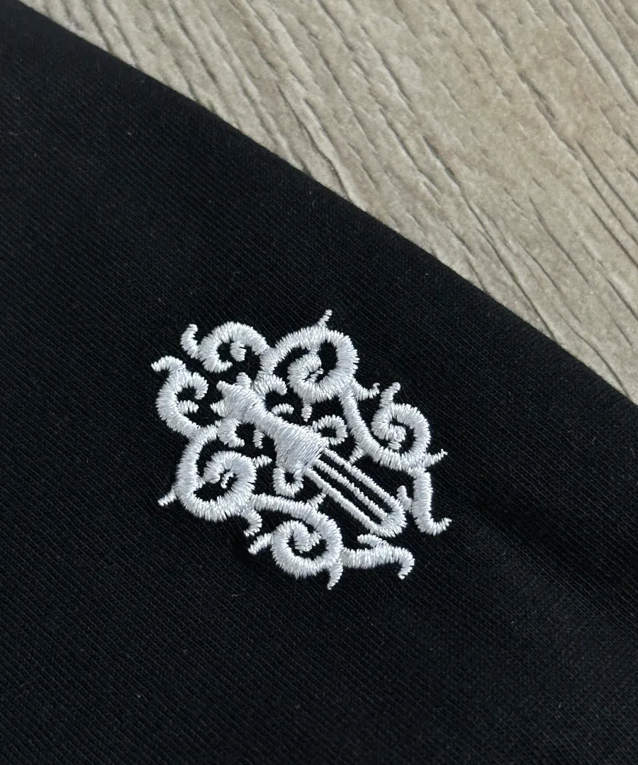 Крупный план вышивки на груди футболки Chrome Hearts GRP Y