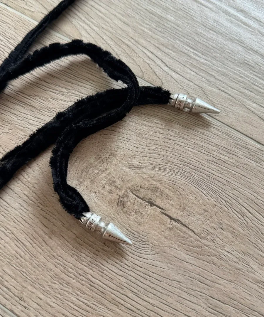 Деталь завязок черного топа Chrome Hearts с серебряными наконечниками