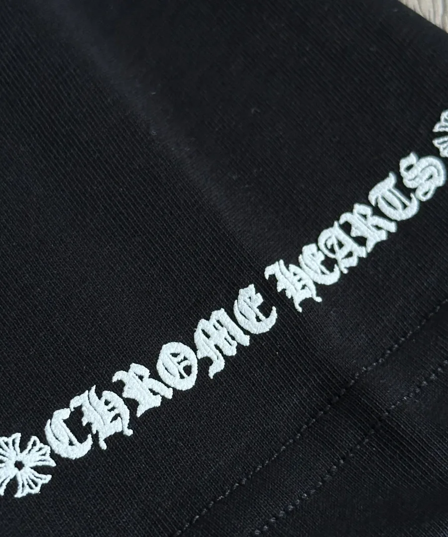 Деталь принта на рукаве черной футболки Chrome Hearts