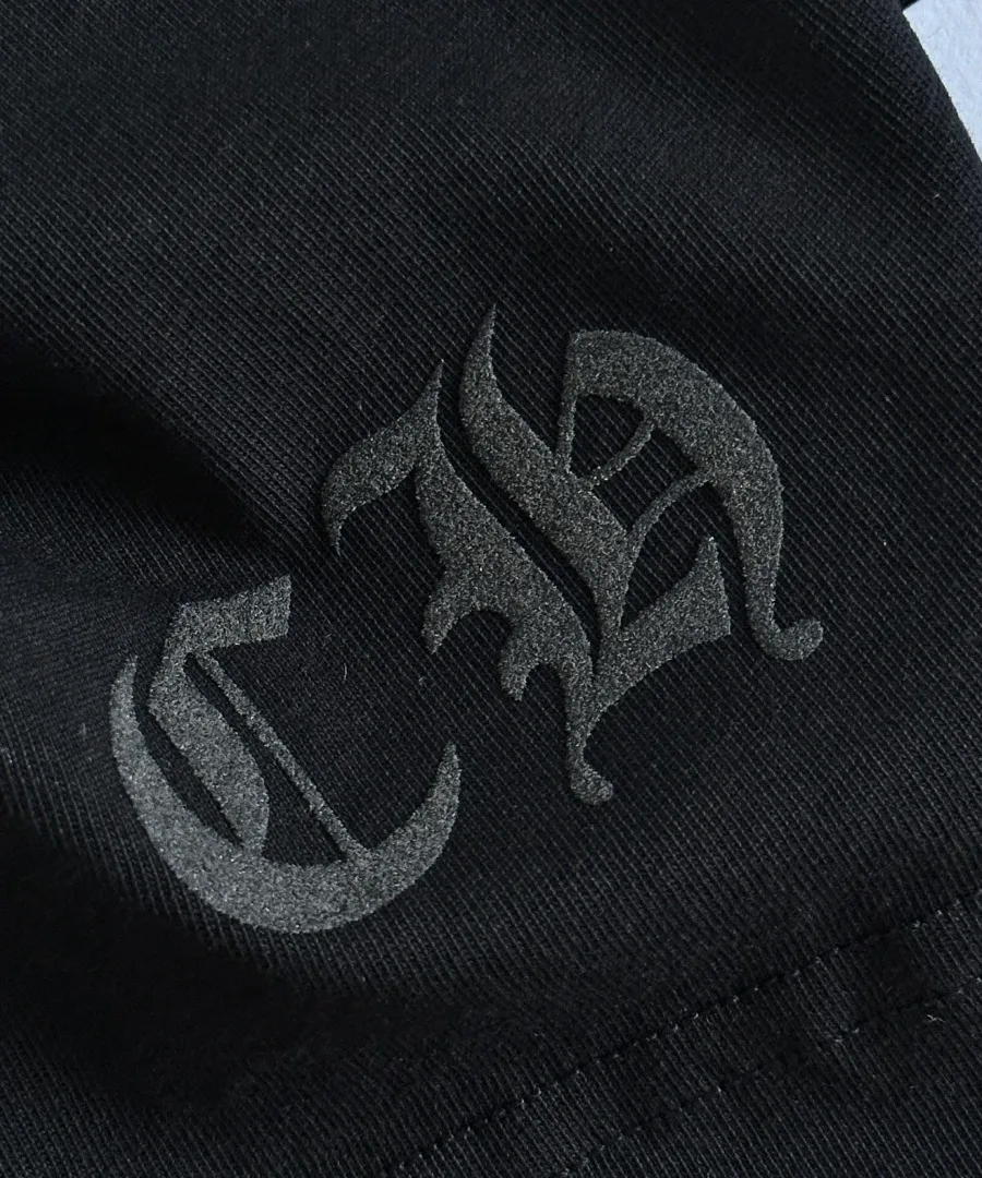 Деталь тиснения CH на черной футболке Chrome Hearts