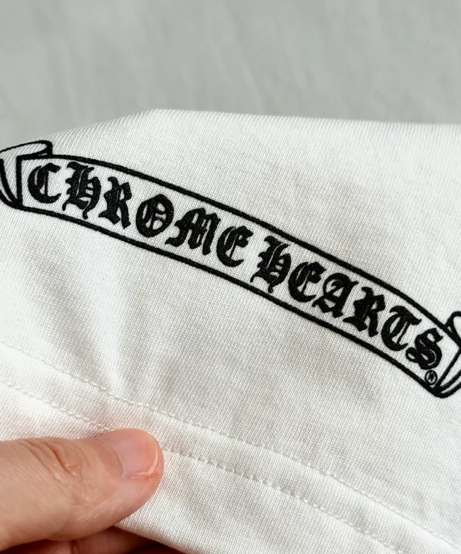 Деталь принта на рукаве белой футболки Chrome Hearts