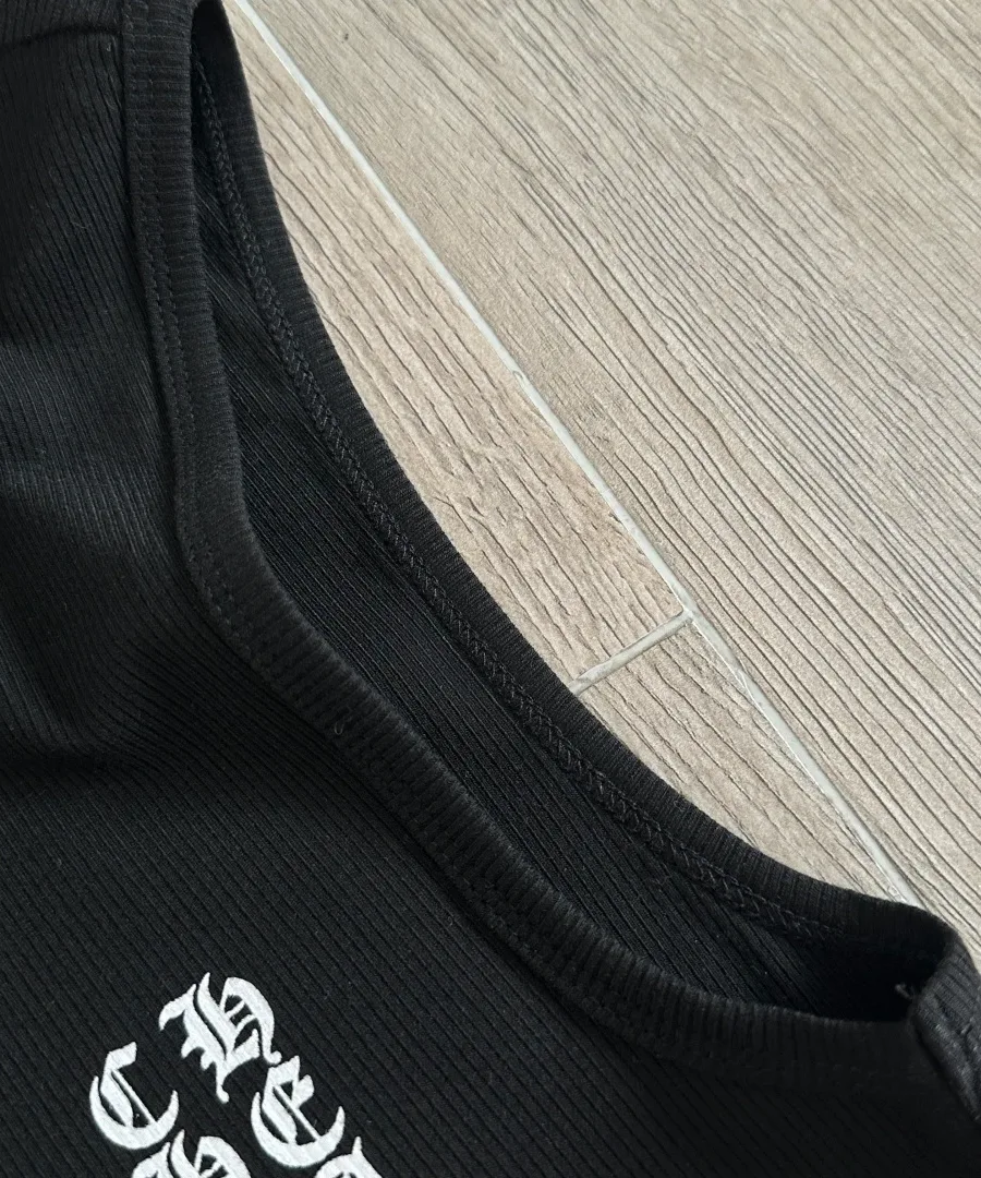 Крупный план окантовки горловины платья-майки Chrome Hearts