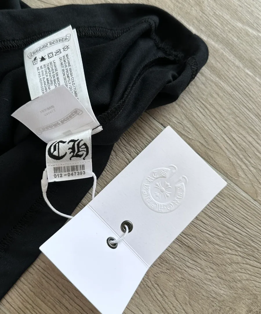 Фирменные бирки на черной футболке Chrome Hearts