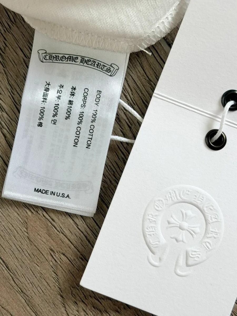 Фирменные бирки на белой футболке Chrome Hearts