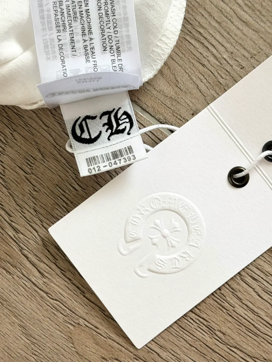 Деталь фирменной бирки белой футболки Chrome Hearts