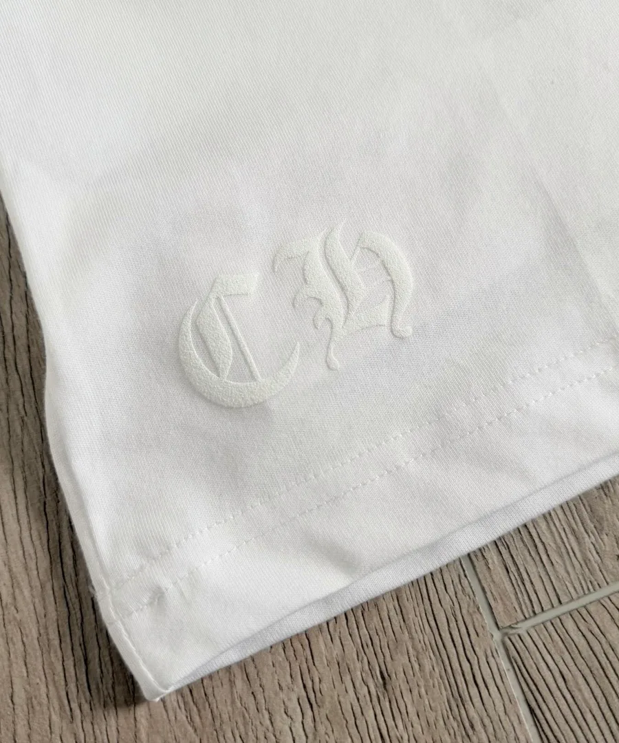 Вышивка CH на нижнем крае белой футболки Chrome Hearts