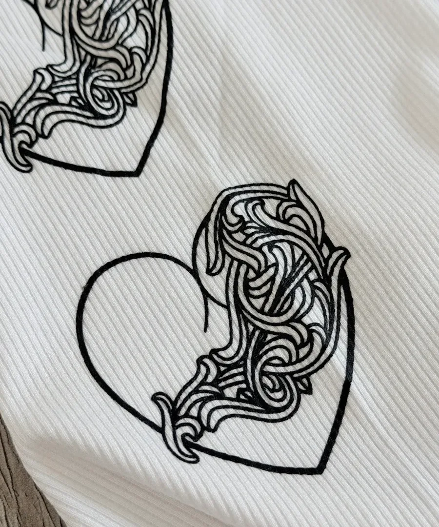 Крупный план принта в виде сердца на майке Chrome Hearts