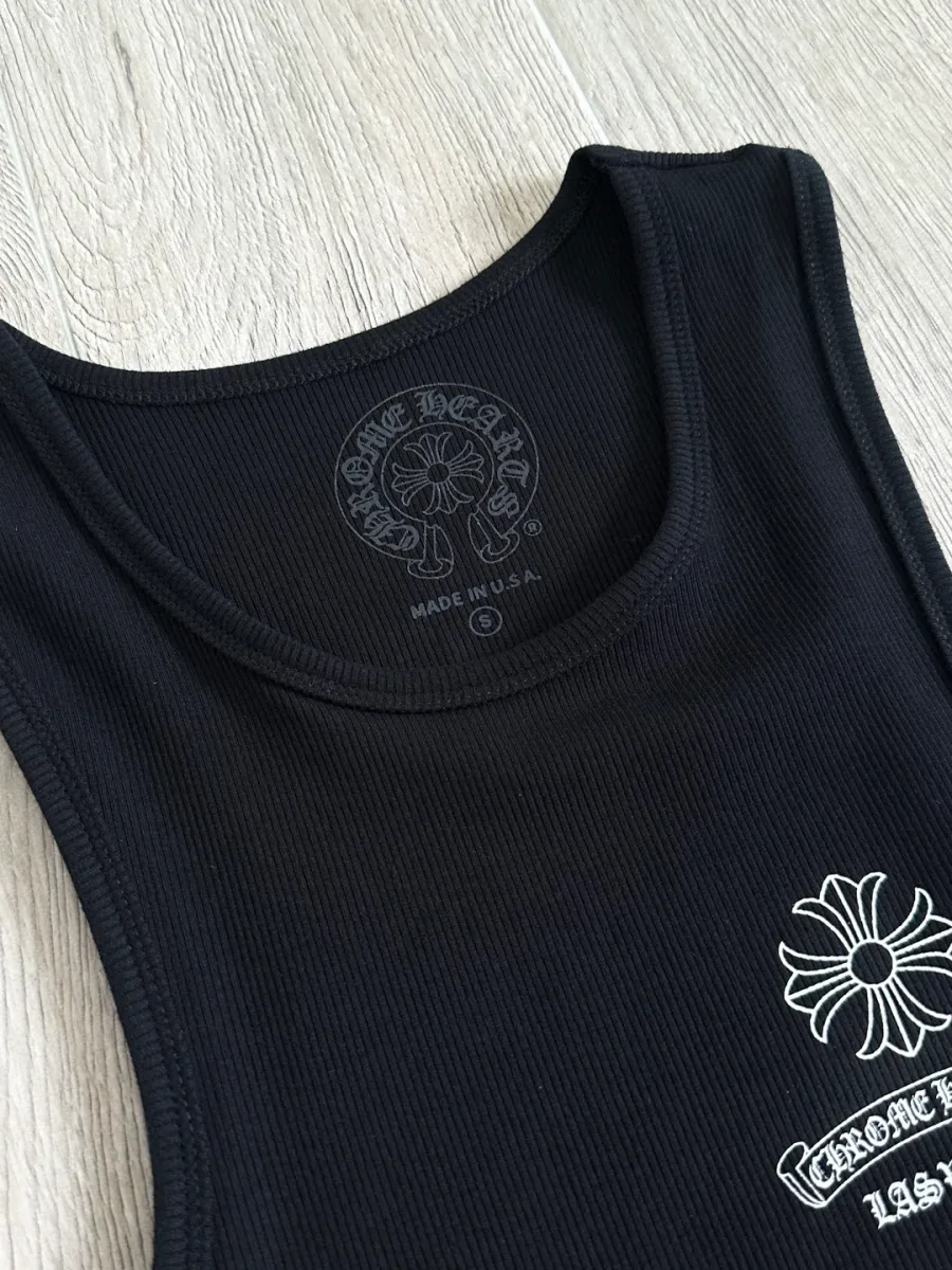 Крупный план выреза горловины и логотипа на груди черной майки Chrome Hearts