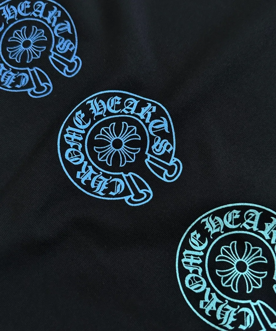 Крупный план голубых принтов-подков на черной футболке Chrome Hearts