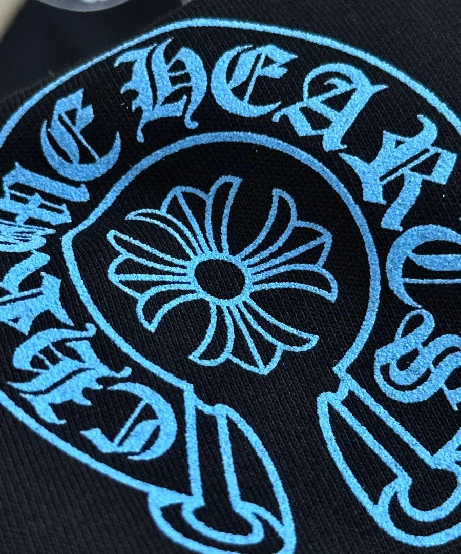 Крупный план синего принта-подковы на черной футболке Chrome Hearts