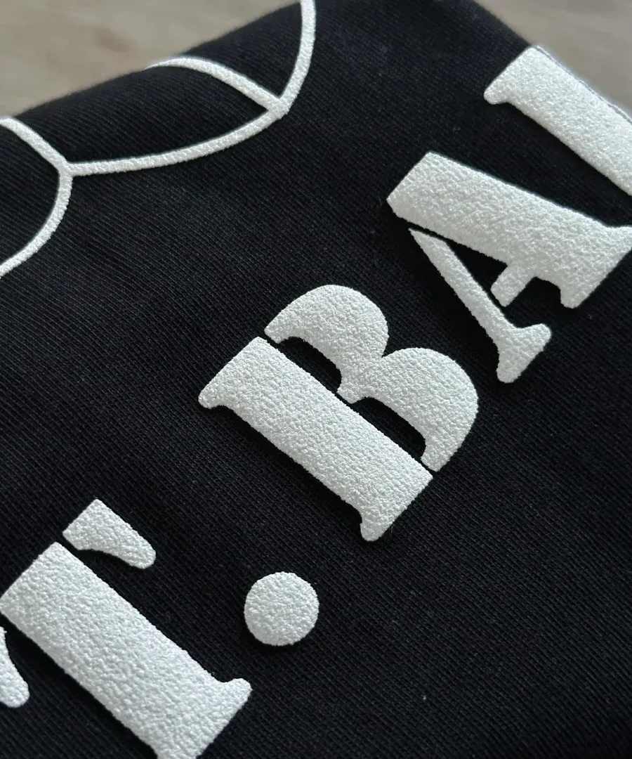 Деталь принта ST. BARTH крупным планом на черном лонгсливе Chrome Hearts