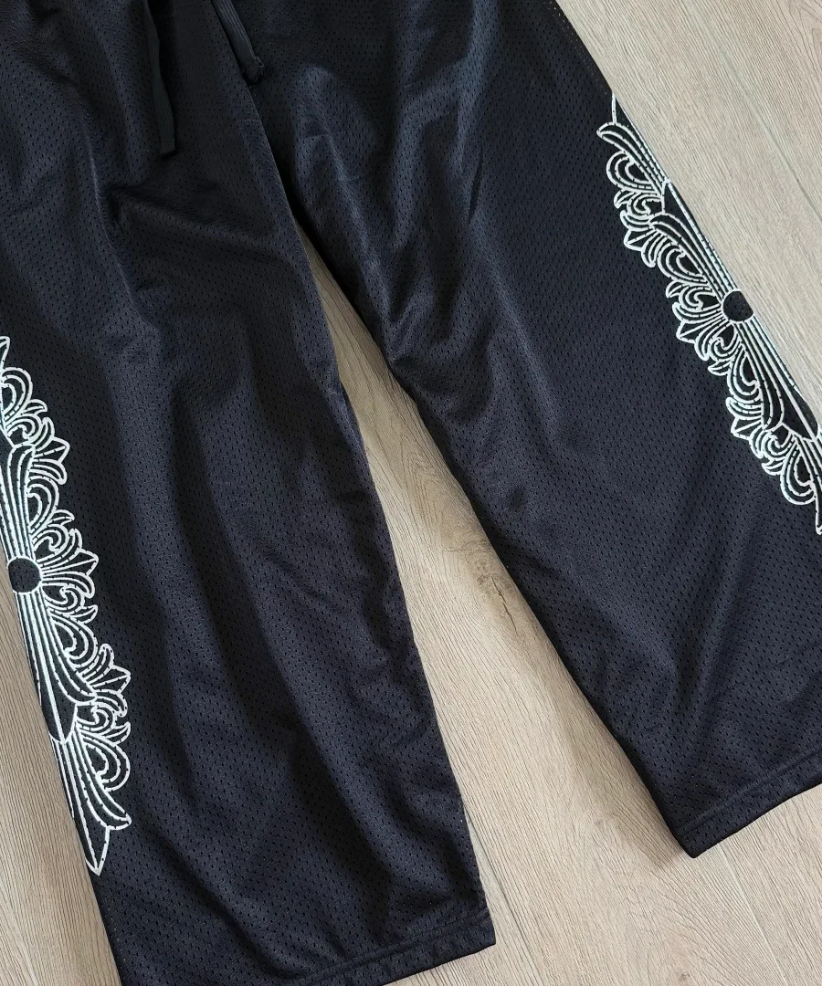 Деталь штанин черных спортивных штанов Chrome Hearts с принтами