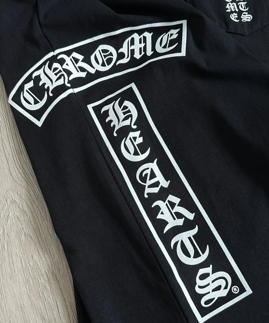 Готический шрифт на боку черной футболки Chrome Hearts
