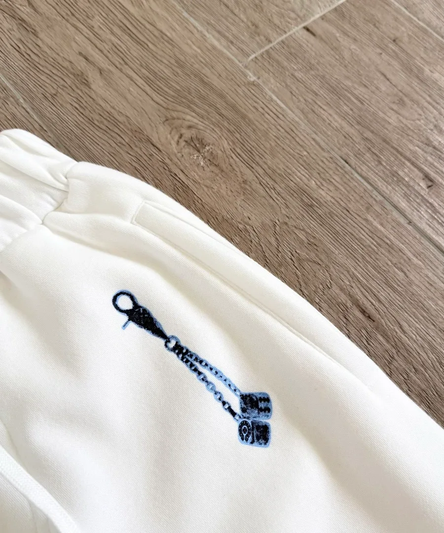 Крупный план принта с игральными костями на белых штанах Chrome Hearts