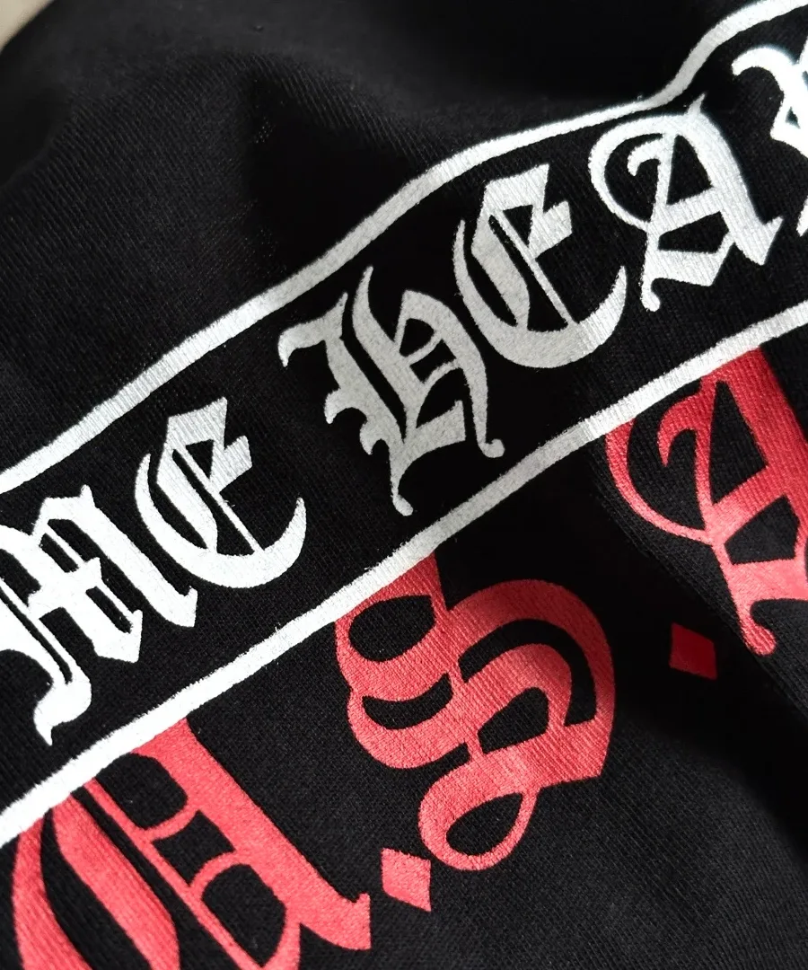 Крупный план принта Chrome Hearts U.S.A. на чёрной футболке