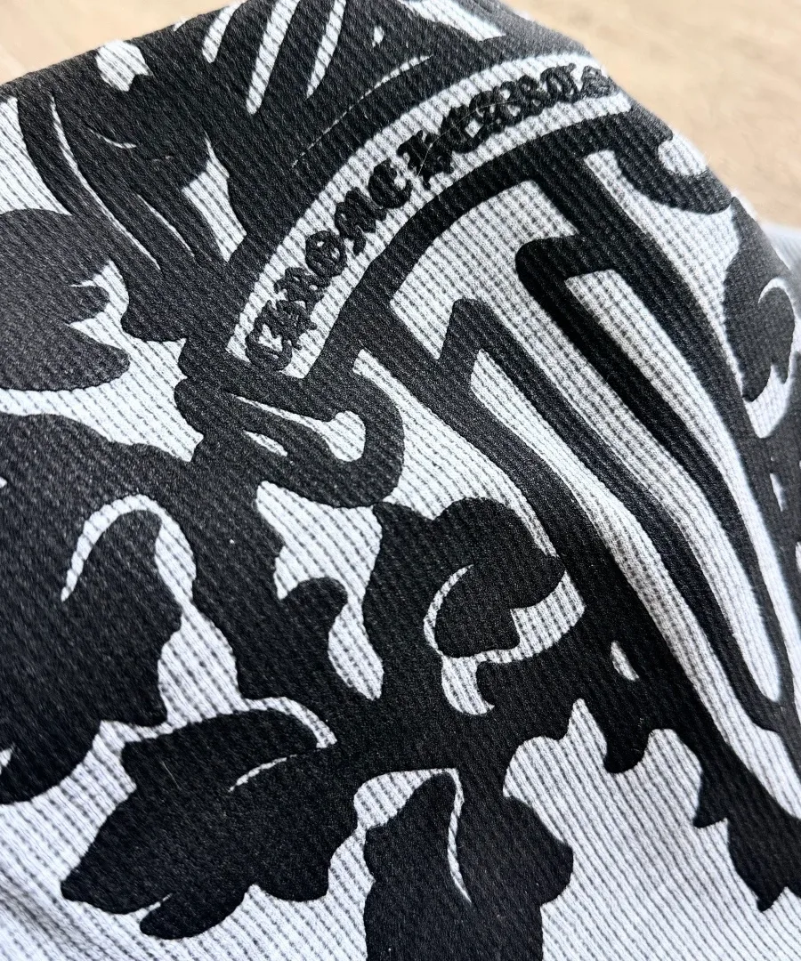 Деталь черного принта на сером вафельном трикотаже Chrome Hearts
