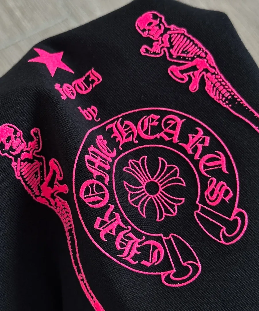 Деталь неоново-розового принта на черной футболке Chrome Hearts