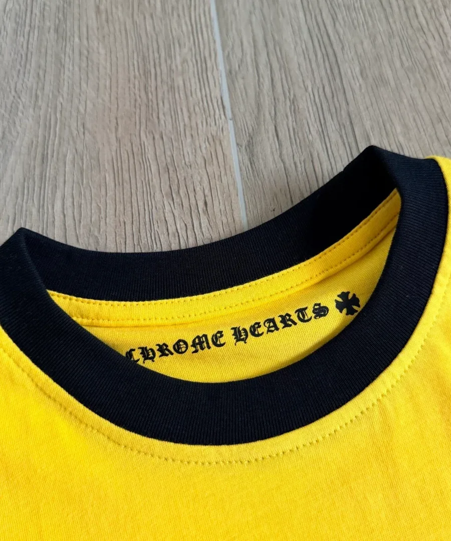 Деталь воротника желтой футболки Chrome Hearts с черной окантовкой