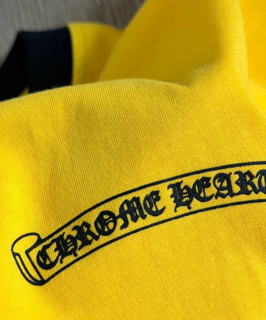 Деталь принта Chrome Hearts на желтом трикотаже