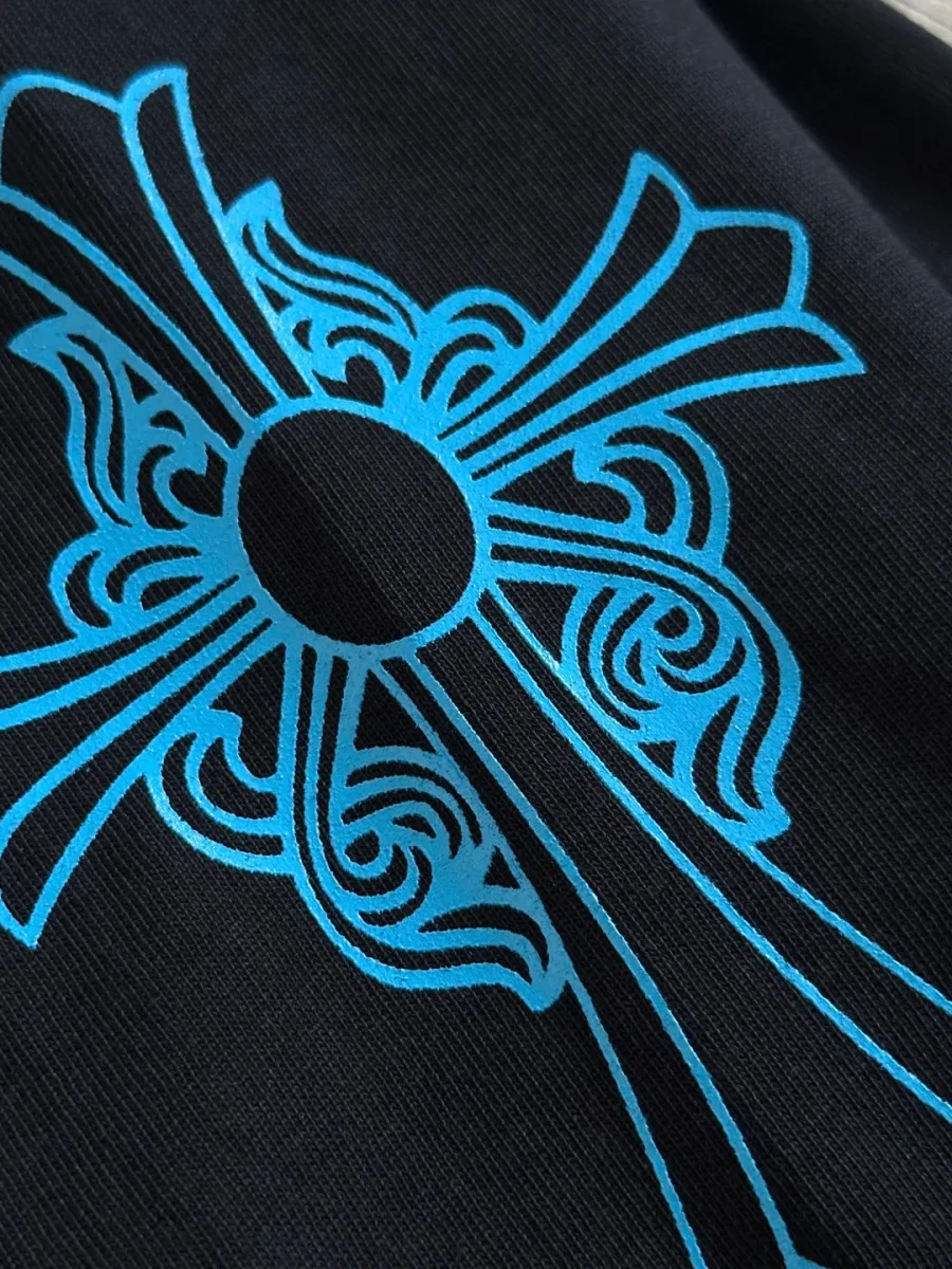 Крупный план синего принта в виде креста на черном лонгсливе Chrome Hearts