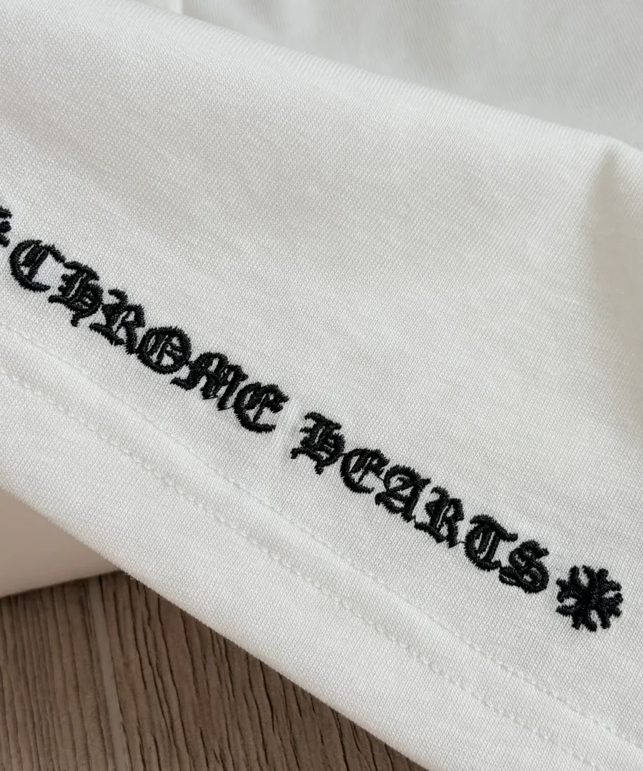 Вышивка названия бренда на нижнем крае белого лонгслива Chrome Hearts GRP Y