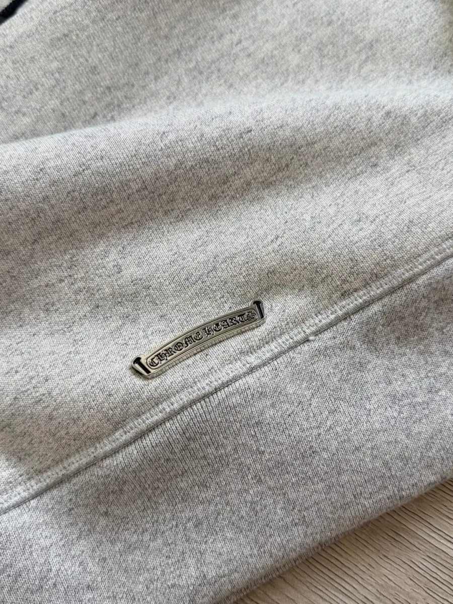 Деталь серебряной фурнитуры с логотипом Chrome Hearts на спинке худи
