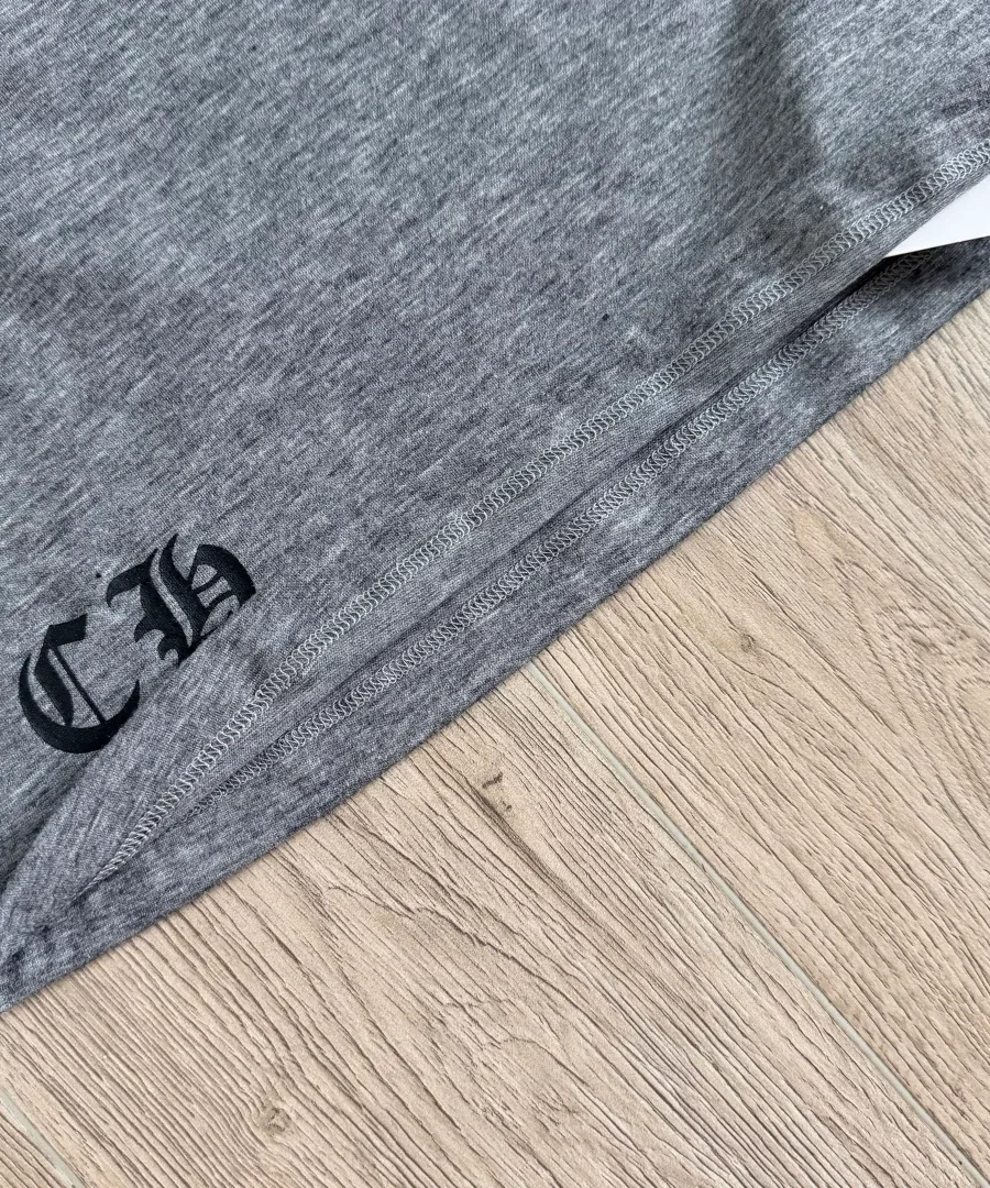 Нижний край серой футболки Chrome Hearts с монограммой CH