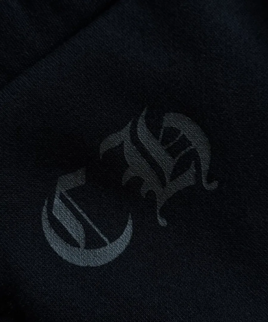 Деталь вышивки логотипа CH на черных штанах Chrome Hearts