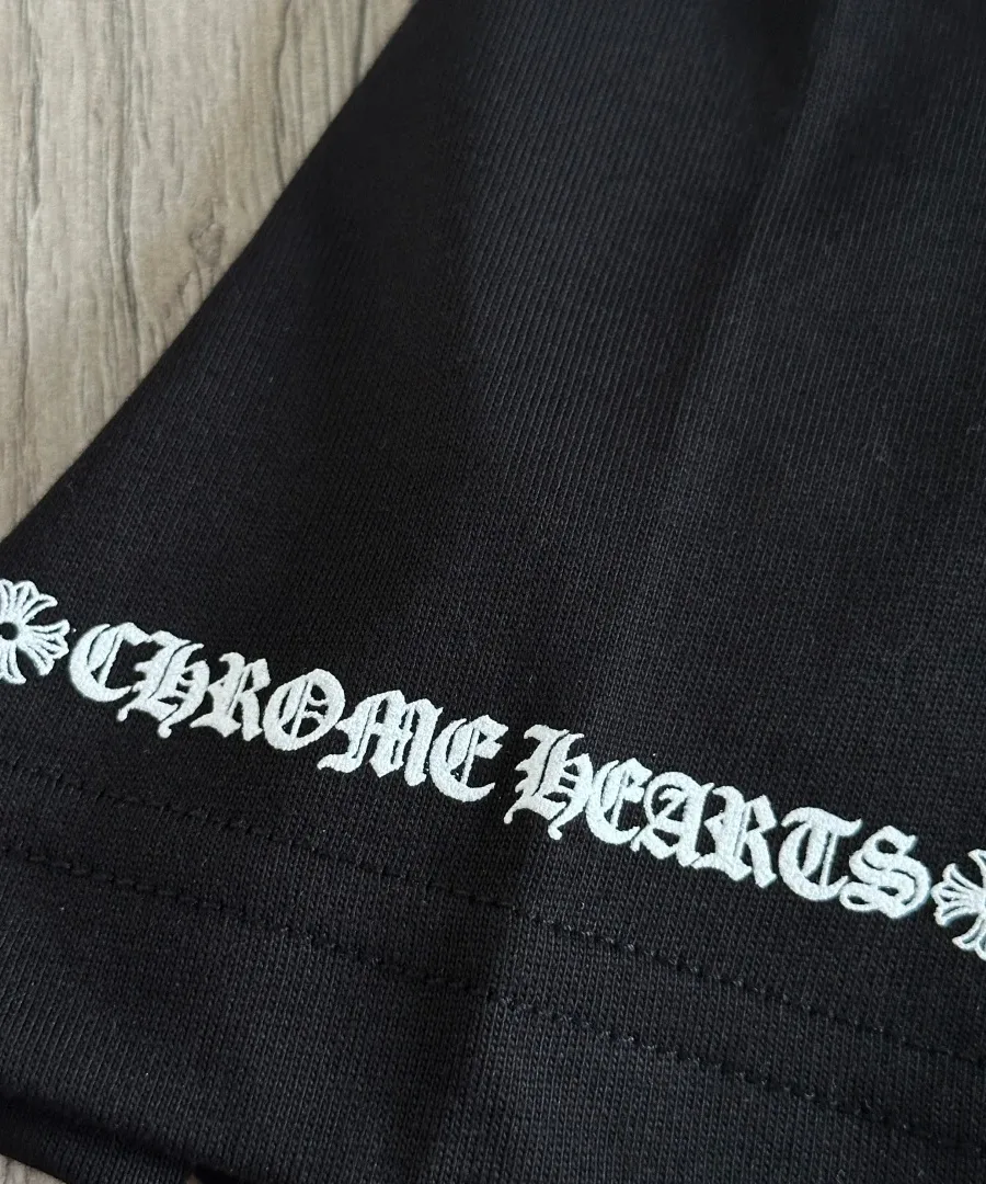 Деталь принта на рукаве черной футболки Chrome Hearts
