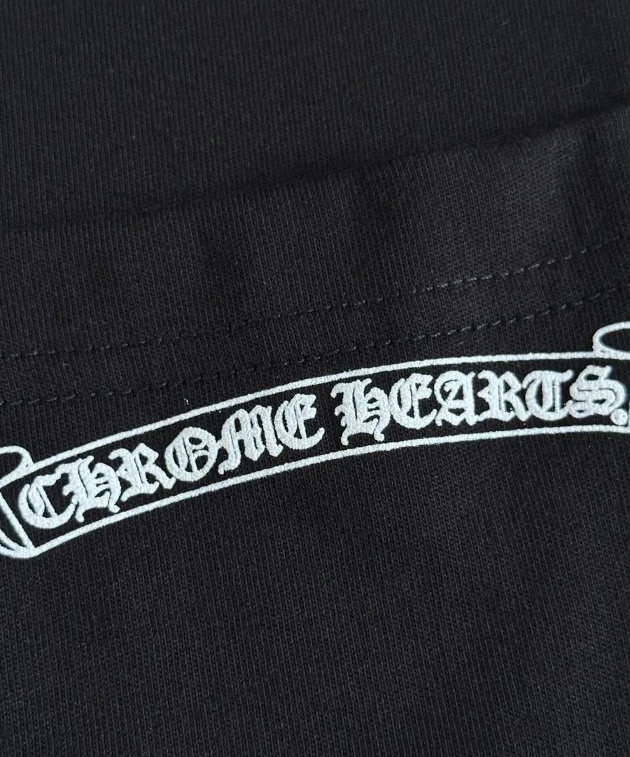 Деталь принта на кармане черной футболки Chrome Hearts