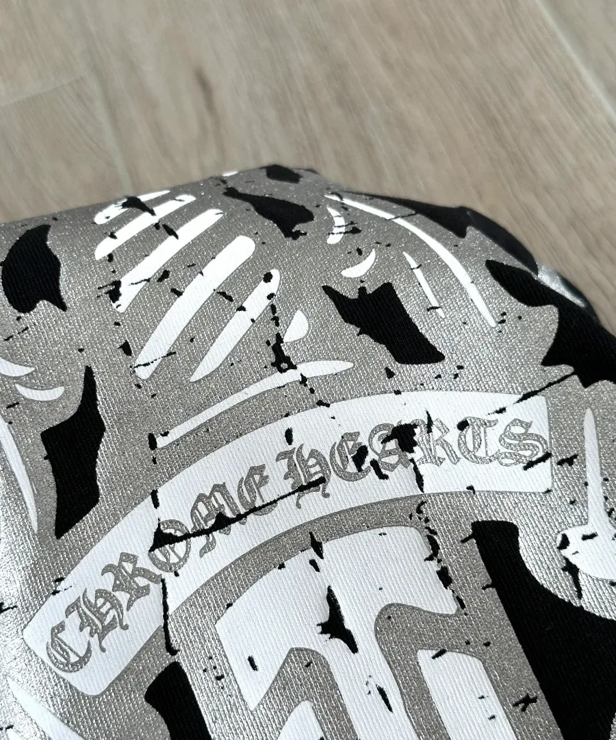 Деталь серебристого принта черного лонгслива Chrome Hearts