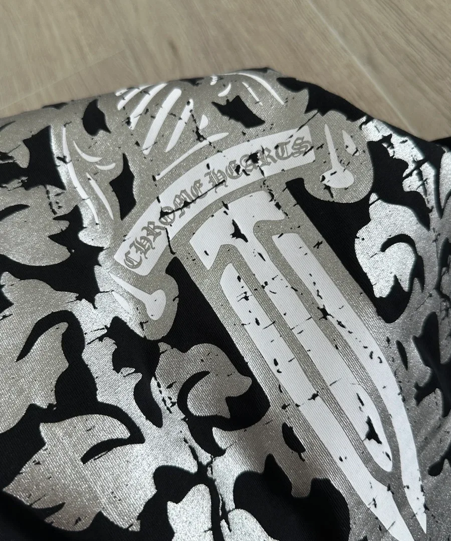 Деталь серебристого принта на спине черного лонгслива Chrome Hearts