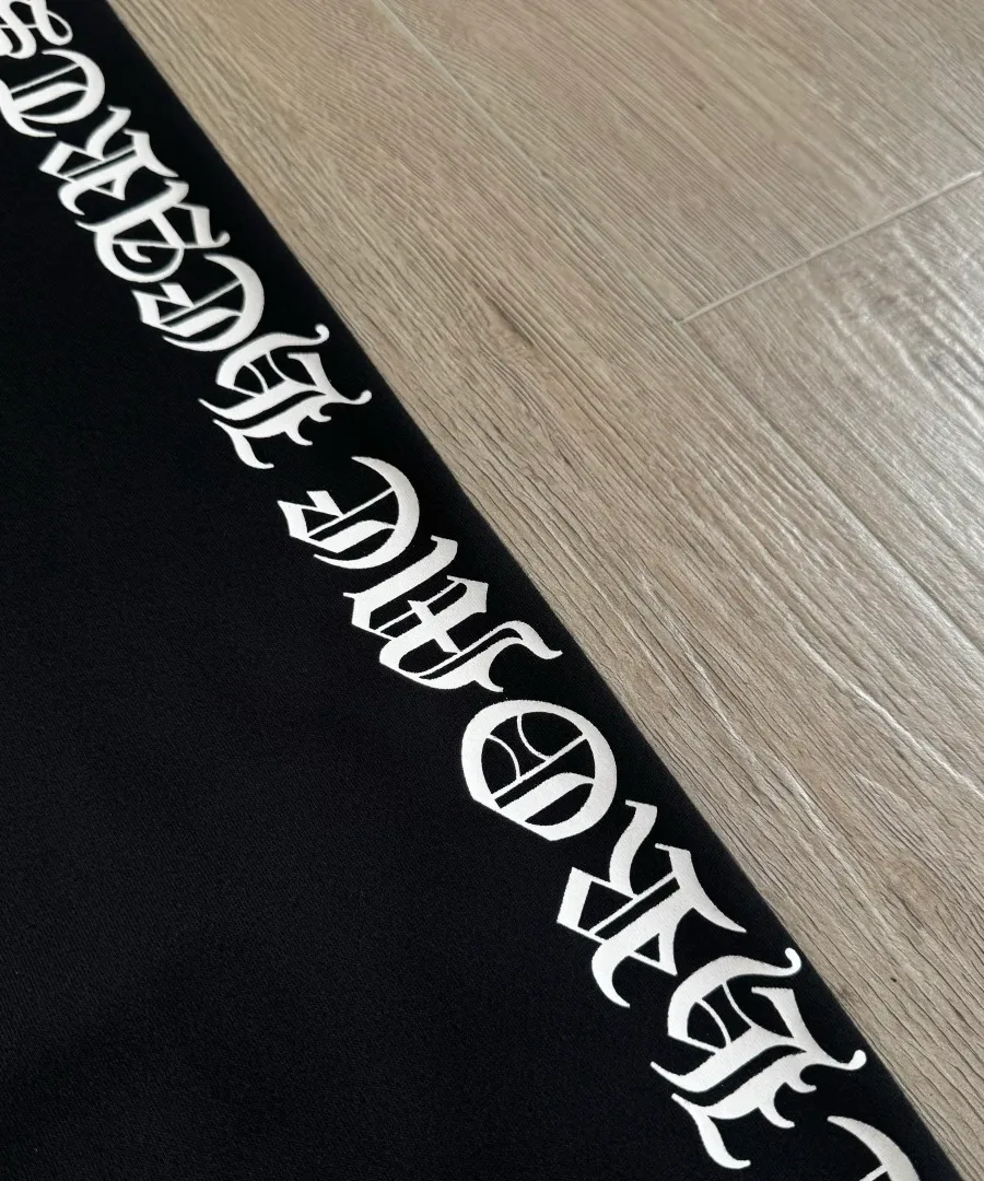 Крупный план готического принта Chrome Hearts на штанине