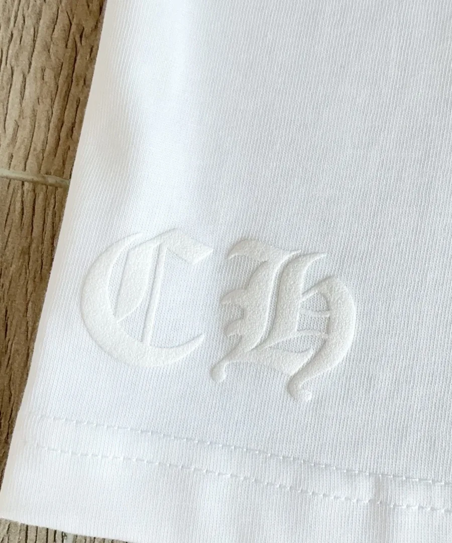Деталь вышивки CH на подоле белого лонгслива Chrome Hearts