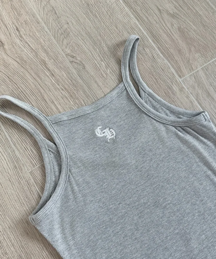 Вышивка монограммы CH на спинке серого платья Chrome Hearts