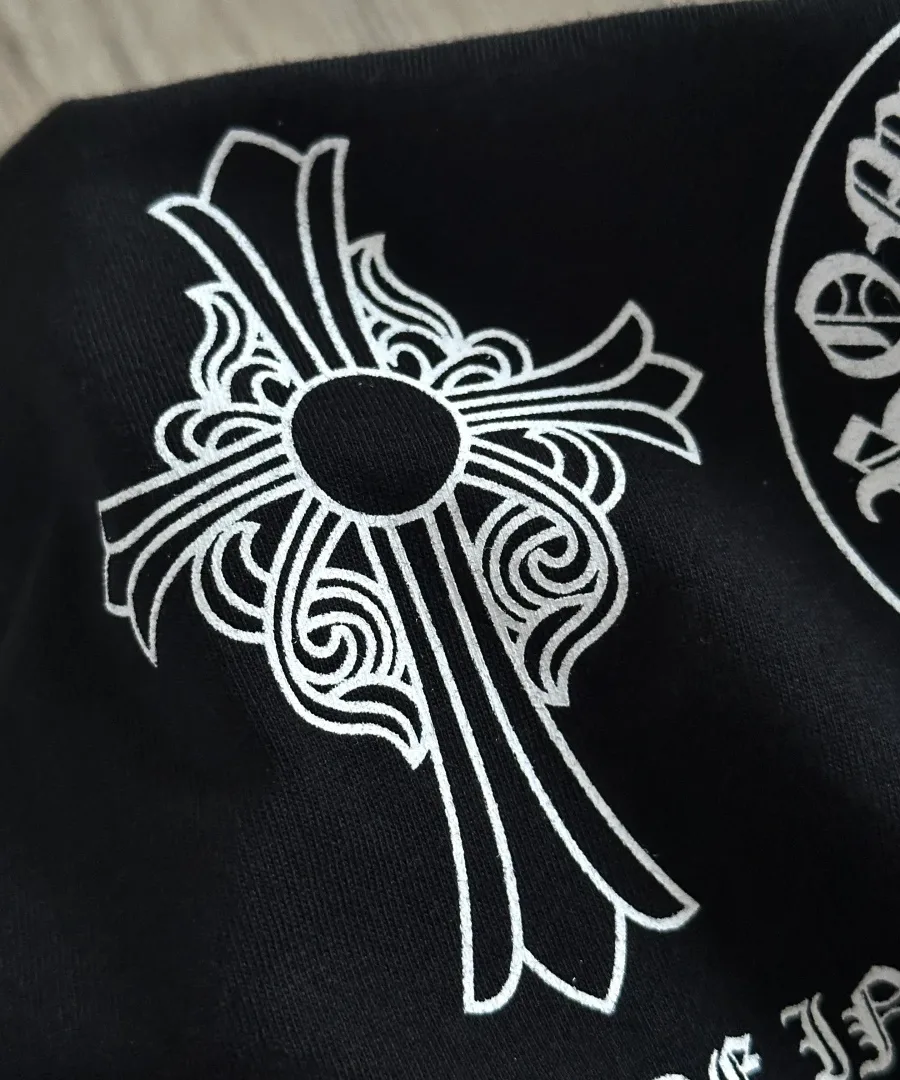 Крупный план принта с геральдическим крестом на черной футболке Chrome Hearts
