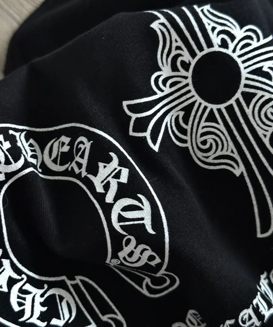 Деталь принта с подковой и крестом на черной футболке Chrome Hearts
