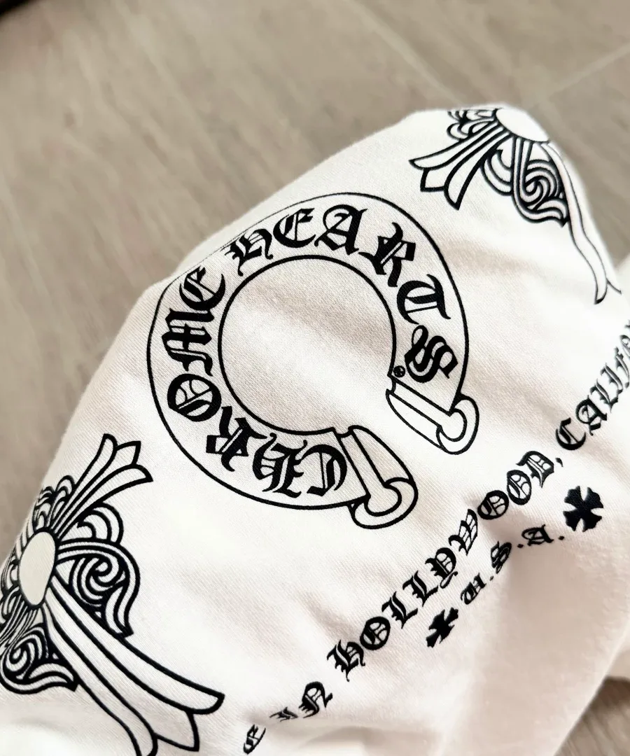 Крупный план принта с подковой и крестом на белой футболке Chrome Hearts