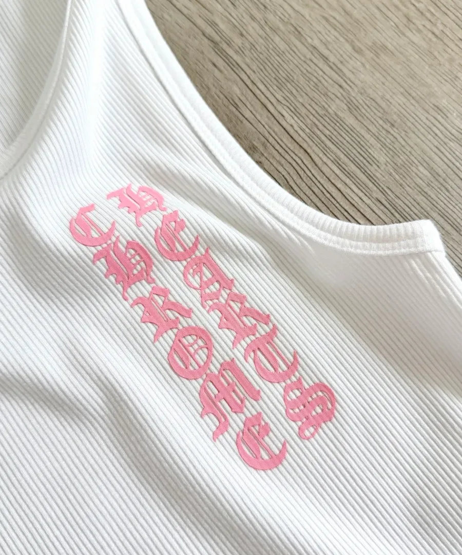 Крупный план розового готического принта на белой майке Chrome Hearts