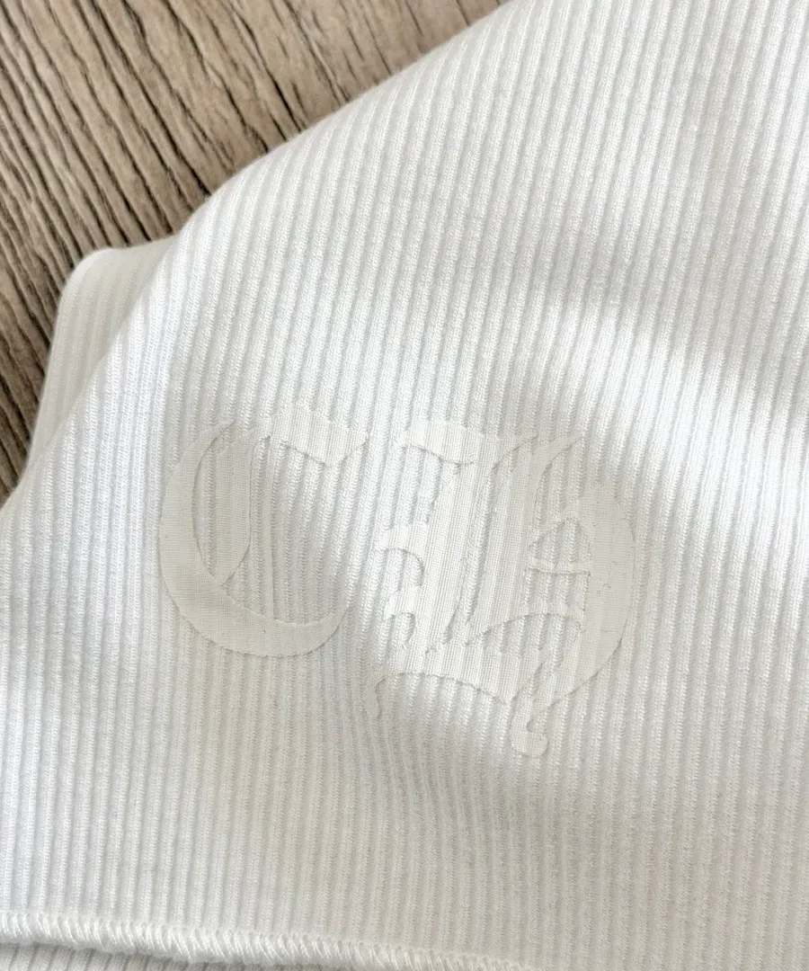 Крупный план белого тисненого принта на майке Chrome Hearts