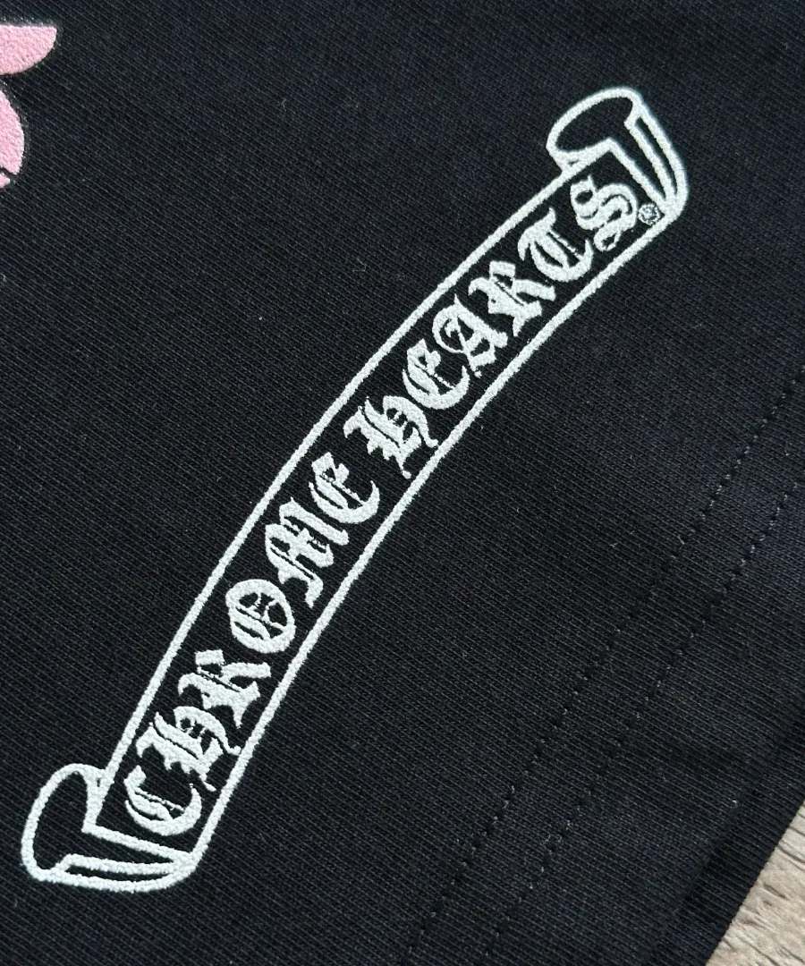 Деталь логотипа Chrome Hearts на черном лонгсливе