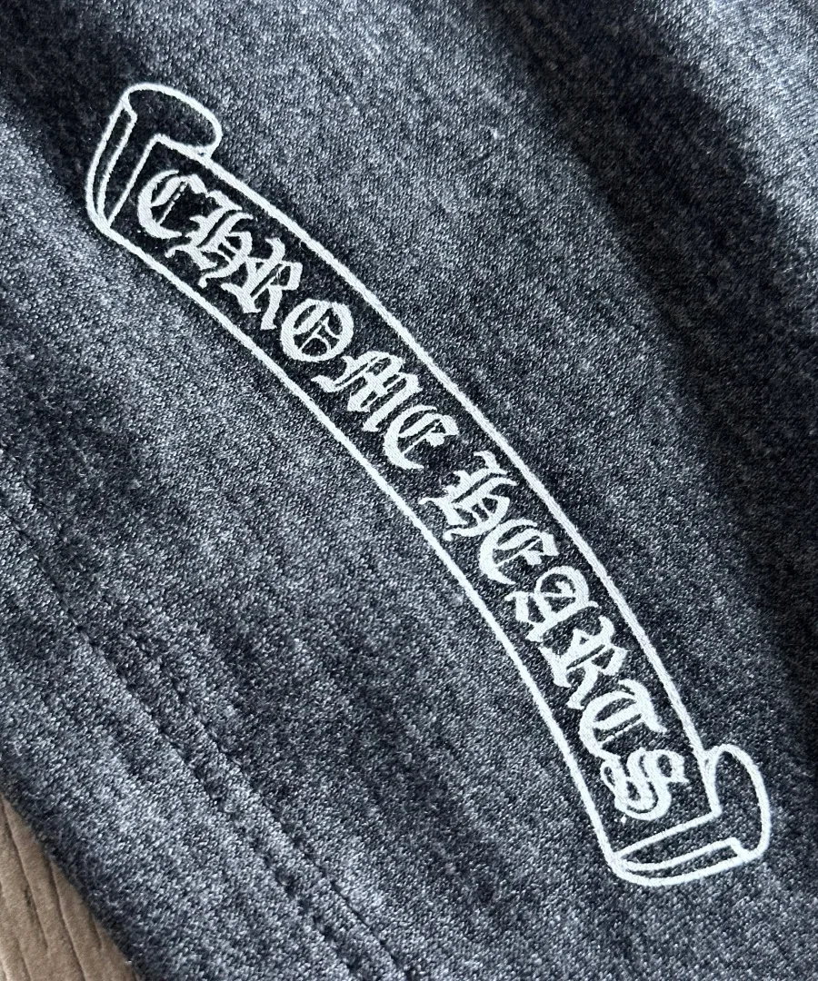 Крупный план готического принта Chrome Hearts на серой футболке