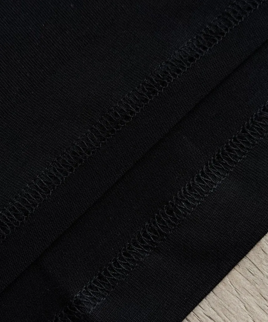 Обработка нижнего края черной футболки Chrome Hearts