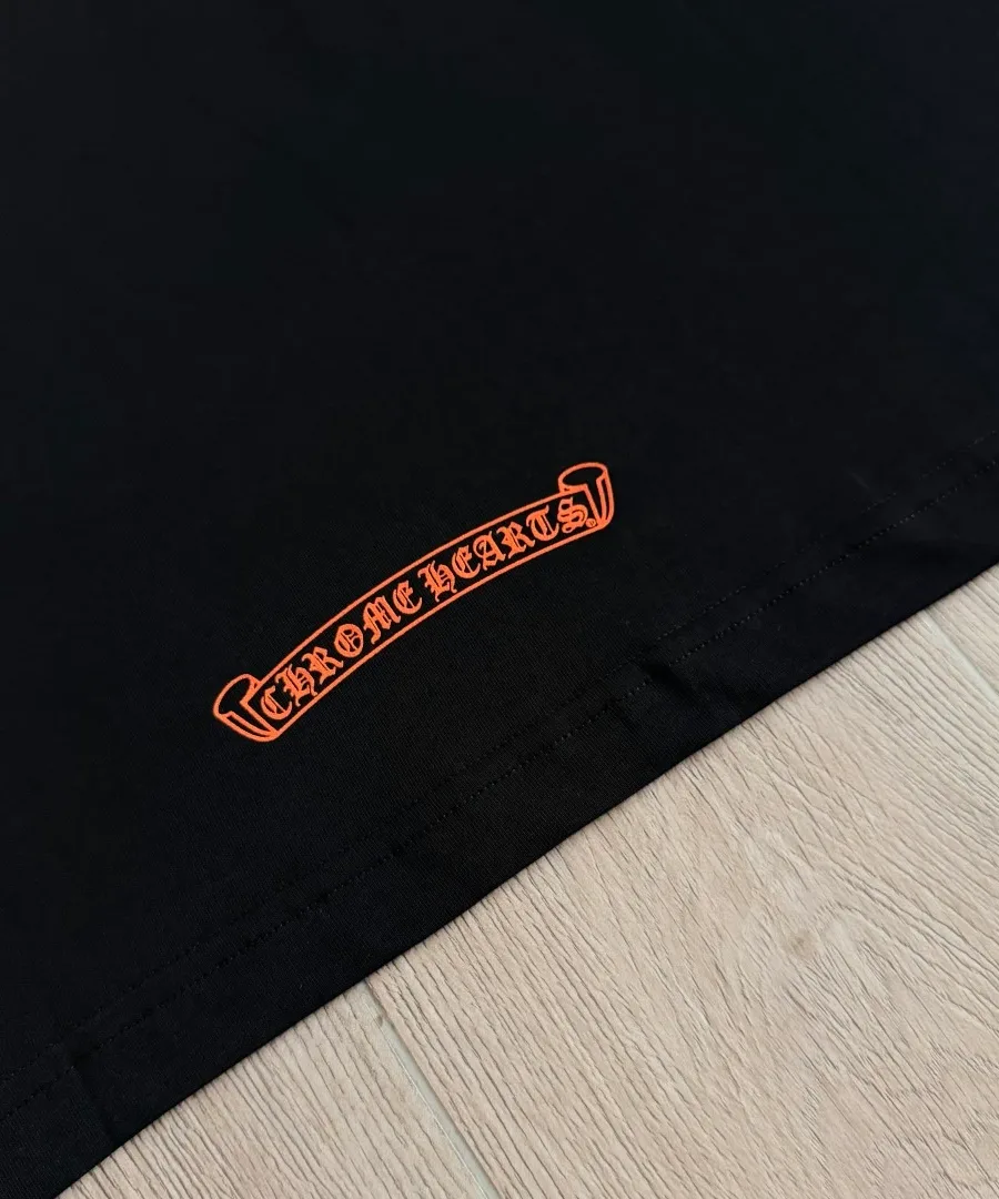 Деталь принта с логотипом Chrome Hearts на черной футболке