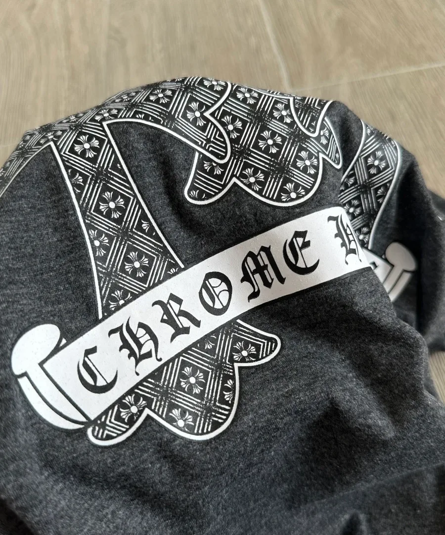 Деталь графичного принта Chrome Hearts на сером меланжевом трикотаже