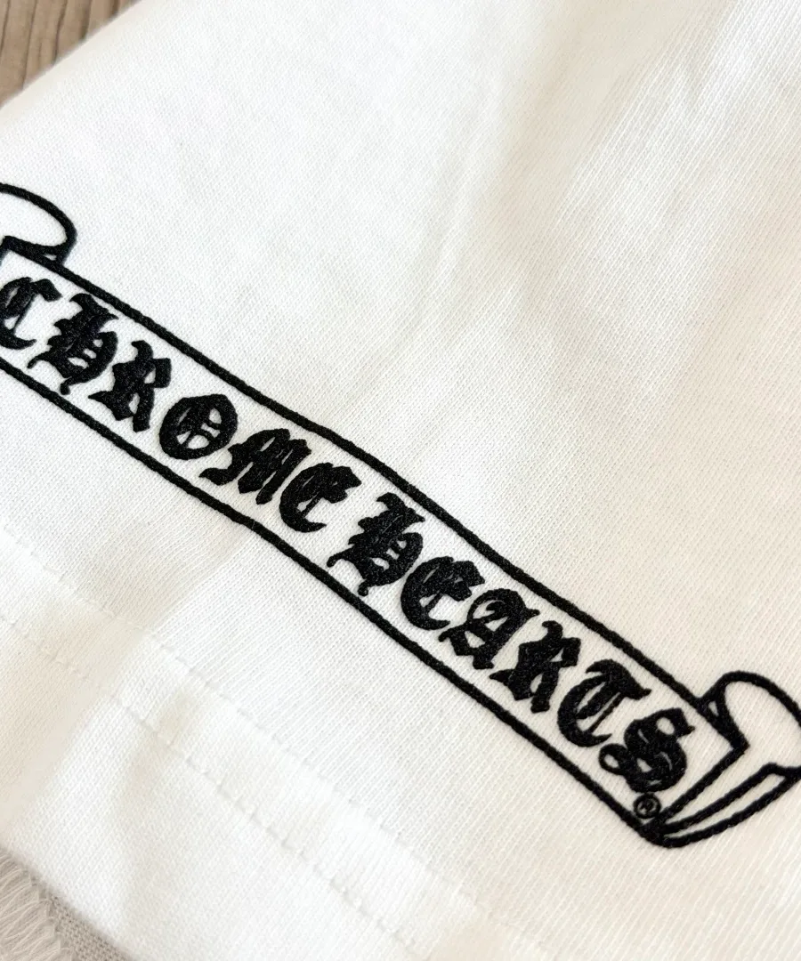 Крупный план логотипа-свитка Chrome Hearts на белой футболке